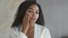 Mirror Pov Of Young Attractive African American Lady Applying Moisturizing Cream On Face, Taking Care About Appearance