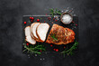 © Sea Wave - Christmas turkey ham roasted for festive dinner on black background. Top view