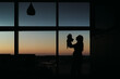 © Cavan Images - Silhouette of mother and newborn in hospital room at sunset