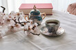 © Cavan Images - Still life of a book, coffee cups and almond blossoms. Reading c
