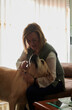 © Cavan Images - Middle-aged woman petting and playing with her Labrador dog at home
