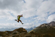 © Cavan Images - A man jumps into the air in front of mountain landscape