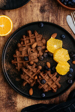 Homemade Chocolate Waffles With Blueberries On A Dark Wooden Backgroun
