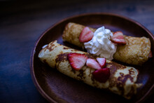 Close up of crepes with berries and creme on a table