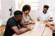© PICHA - Friends playing cards while enjoying wine at home