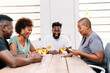© PICHA - Friends playing cards while enjoying wine at home