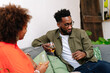 © PICHA - couple sitting on a couch having drinks