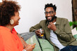 © PICHA - couple sitting on a couch having drinks