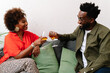 © PICHA - couple sitting on a couch having drinks