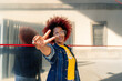© Cavan Images - woman with afro hair making victory gesture