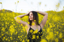 Beautiful Woman Enjoying Springtime In Tall, Yellow Wildflower Field