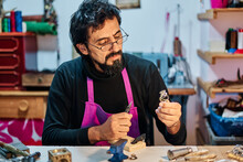 Jeweler Craftsman Looking And Working On Jewel At Work Table