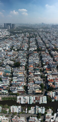 Wall Mural - Aerial vertical panorama of Phu My Hung district of Ho Chi Minh City, Vietnam on sunny clear day featuring canall and Phu My Bridge in the distance.