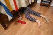 Young boy searching for his lost sock under the bed