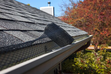 Roll Of Plastic Mesh Guard Over Gutter On A Roof To Keep It Free Of Leaves, Shallow Focus On Roll Of Mesh