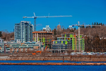 Wall Mural - 
Construction of a new high-rise buildings in the city side of the riverbank of Vancouver City
