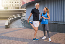 Full Length Shot Of Happy Middle Aged Couple, Man And Woman In Sportswear Smiling, Standing Together Outdoors Ready For Workout