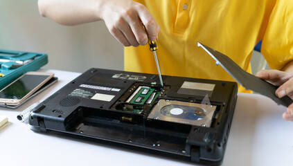 Repairmen are repairing and cleaning laptops periodically