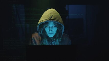 Wall Mural - professional female hacker working on laptop computer in the dark. zoom-in