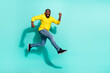 Full length profile side photo of guy jump run sporty shopping marathon isolated over cyan color background