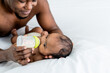 Blurred soft of African black skin  father feeding milk from bottle milk to his  baby newborn daughter, to African family and food for infant concept.