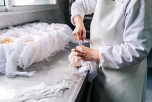 Skilled Chef Wrapping Cheese In Cloth At Factory