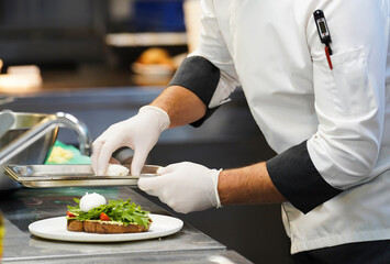 Chef cooking food in restaurant kitchen, close-up