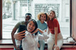 group of multiethnic expats students taking selfies with mobile phone
