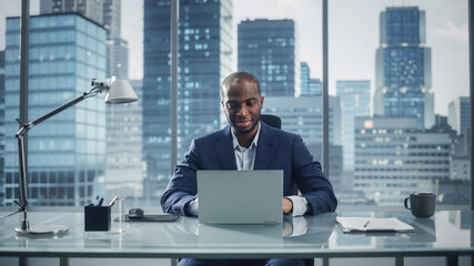 Poster - Portrait of Successful Black Businessman Working on Laptop Computer in His Big City Office. Professional Digital Entrepreneur does Data Analysis for e-Commerce Strategy assessment.
