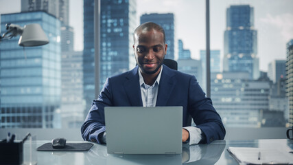 Poster - Portrait of Successful Black Businessman Working on Laptop Computer in His Big City Office. Professional Digital Entrepreneur does Data Analysis for e-Commerce Strategy assessment.