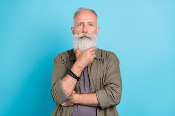 Sticker - Photo of think old man touch beard wearing khaki shirt isolated over blue color background