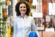 © Westend61 - Smiling female expert with hardhat standing at industry