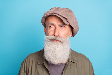 Sticker - Photo of unsure white beard elder man look empty space wear peaky blinder khaki shirt isolated on blue color background