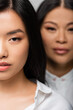 © LIGHTFIELD STUDIOS - close up of asian young adult daughter near blurred mother standing behind