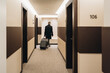 © Westend61 - Businessman walking with briefcase and luggage at hotel corridor