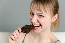 Portrait Of Young Woman Eating Chocolate, Smiling