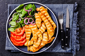 Wall Mural - grilled chicken strips on a plate with vegetables