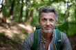 © Westend61 - Smiling handsome male hiker with backpack in forest