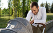 © Westend61 - Smiling man wearing wireless headphones looking at baby stroller in park