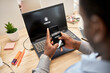 © Westend61 - Businessman protecting data while using smart phone over laptop at office