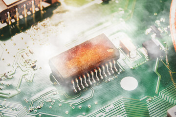 Integrated circuit (IC) burns and smoke on the electronic circuit board of the computer laptop,closeup macro