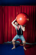 © Westend61 - Male circus acrobat carrying red ball while performing on stage