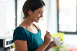 Shot of beautiful happy woman eating yogurt while smiling thinking on her things standing in the kitchen at home.