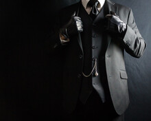 Portrait Of Businessman In Dark Suit And Leather Gloves Standing Proudly. Vintage Style And Retro Fashion.