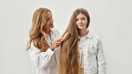 Wall Mural - loving mother brush teen daughter hair