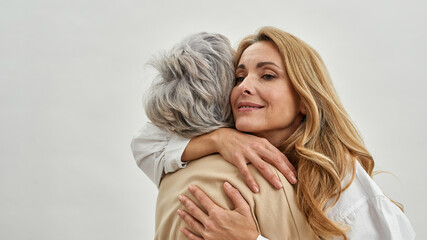 Wall Mural - loving grownup woman daughter embrace old mother
