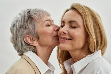 Wall Mural - Older Caucasian mother kiss adult daughter