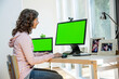 © SuperStock - Young woman using a desktop computer and laptop, sitting in home office.