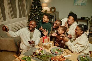 Canvas Print - Portrait of happy African-American family taking selfie photo while enjoying Christmas together