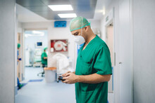Medic With Smartphone In Hospital Corridor